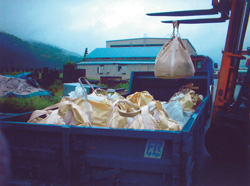 袋詰めされた特別管理産業廃棄物（耐火物）を収集運搬車に積み込む様子